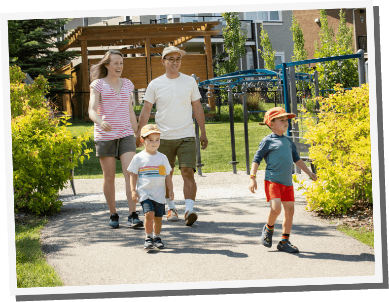 Couple walking along pathway holding hands with their kids walking in front of them