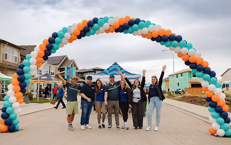 Hopewell team standing under a balloon arch