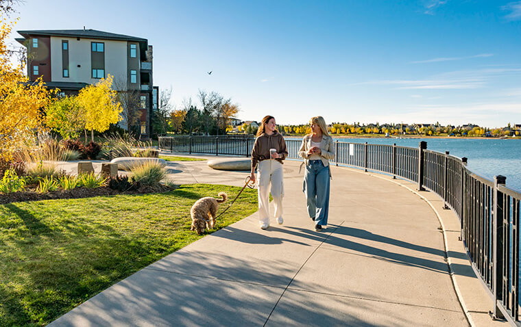 2 friends walking their dog drinking coffee