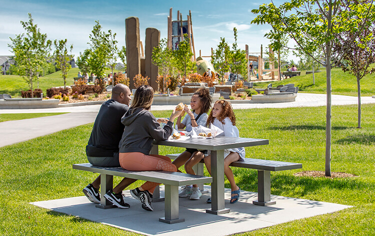 Family of 4 having a picnic at one of Mahogany's park benches